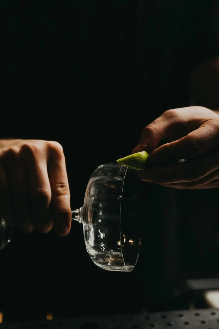 Bartender finalizando taça com casca de limão