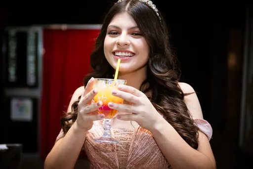 Convidada com drink colorido na festa